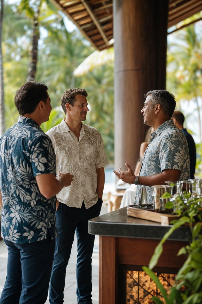 Colleagues in aloha shirts talking at a retreat lanai bar